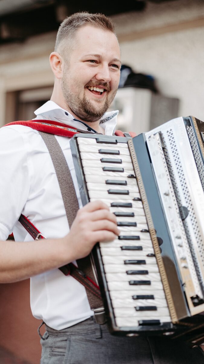 Ein Musiker von Boazn Royal spielt lachend Akkordeon
